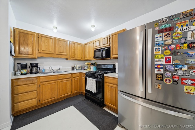 kitchen featuring a sink, black appliances, and light countertops