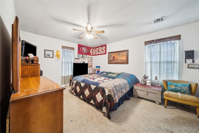 bedroom with carpet, a ceiling fan, and visible vents