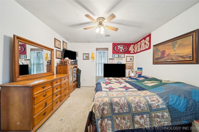 bedroom featuring a ceiling fan, visible vents, and light carpet