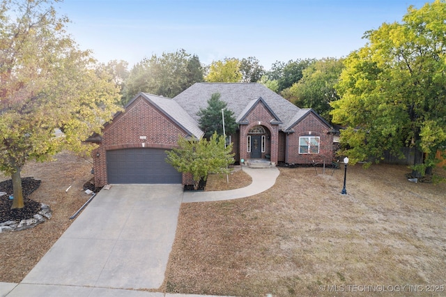 view of front of house featuring a garage, brick siding, driveway, and a shingled roof