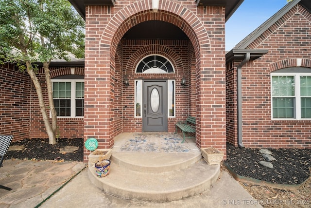 property entrance featuring brick siding