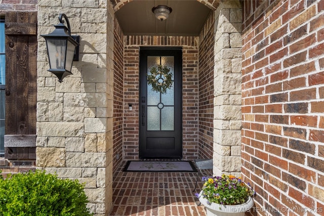 entrance to property featuring brick siding