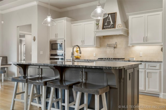 2910 E Olympia St, Broken Arrow, OK 74014 - kitchen with light wood-style floors, stainless steel appliances, tasteful backsplash, and white cabinetry