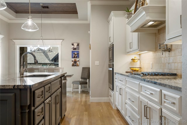2910 E Olympia St, Broken Arrow, OK 74014 - kitchen featuring premium range hood, a raised ceiling, appliances with stainless steel finishes, and a sink