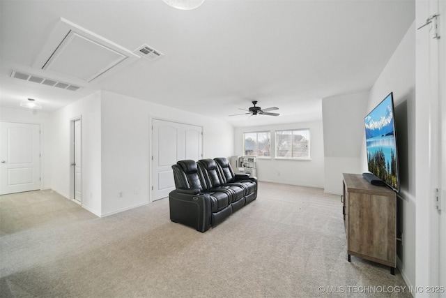 living room featuring attic access, light colored carpet, ceiling fan, and baseboards