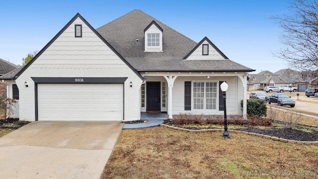 view of front of house featuring a front yard, a shingled roof, concrete driveway, a garage, and brick siding