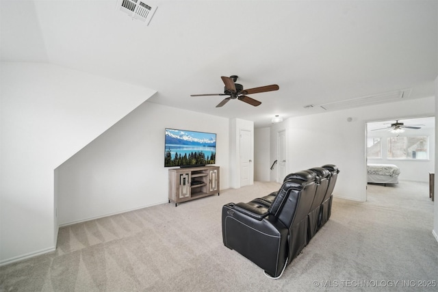 living area featuring attic access, ceiling fan, light carpet, and baseboards