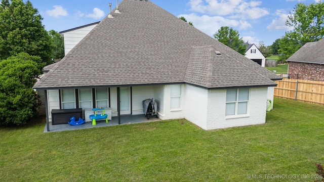 back of house featuring roof with shingles, a patio, and brick siding