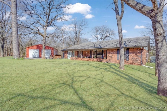 view of front of property with a front lawn, covered porch, an outdoor structure, a garage, and brick siding