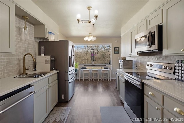 341 S Diamondhead Dr, Burneyville, OK 73430 - kitchen with a sink, dark wood-style floors, appliances with stainless steel finishes, an inviting chandelier, and light countertops