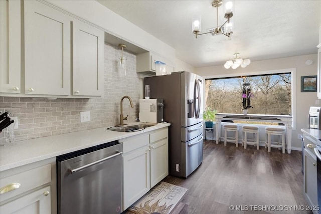 341 S Diamondhead Dr, Burneyville, OK 73430 - kitchen with backsplash, dark wood-style floors, a notable chandelier, stainless steel appliances, and a sink