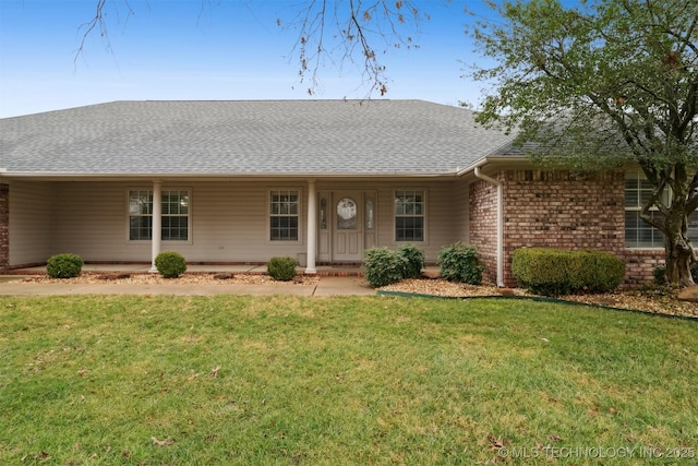 single story home featuring a front yard, brick siding, and a shingled roof