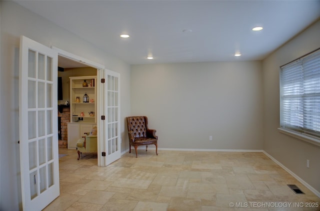 living area featuring visible vents, stone finish flooring, recessed lighting, french doors, and baseboards