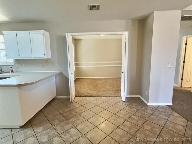 kitchen with visible vents, light colored carpet, and light countertops