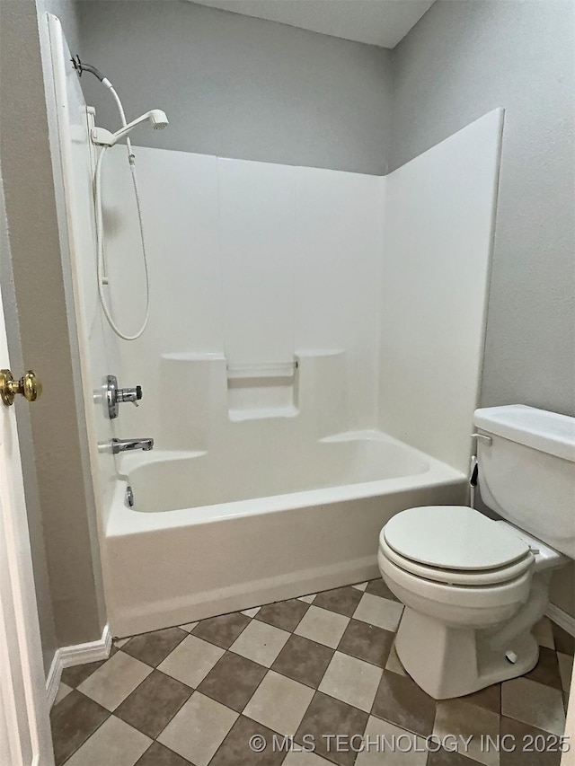 bathroom with baseboards, toilet, and  shower combination