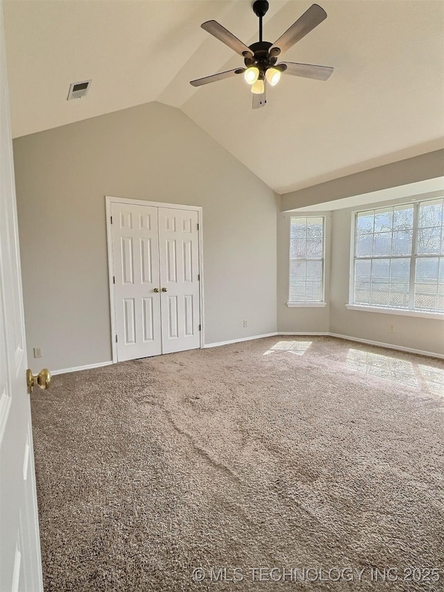 carpeted spare room featuring visible vents, a ceiling fan, baseboards, and vaulted ceiling