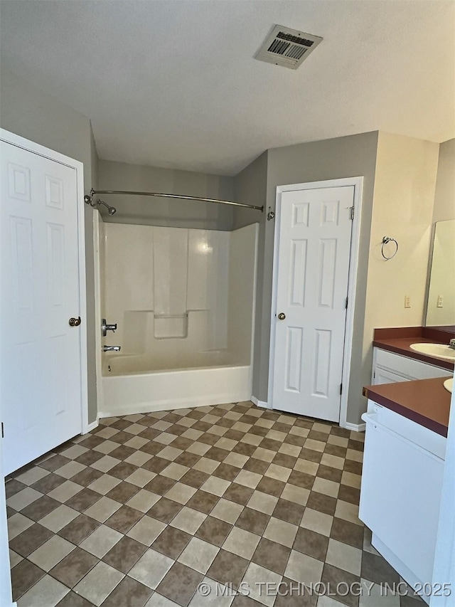 full bathroom with vanity, washtub / shower combination, visible vents, and baseboards