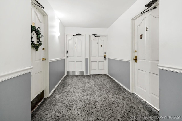 hallway featuring carpet and baseboards