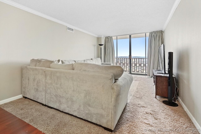 living area with visible vents, baseboards, floor to ceiling windows, ornamental molding, and wood finished floors