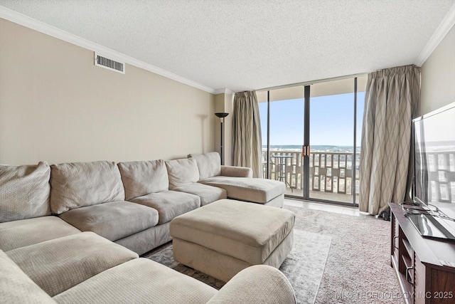 living room featuring visible vents, a textured ceiling, ornamental molding, and floor to ceiling windows