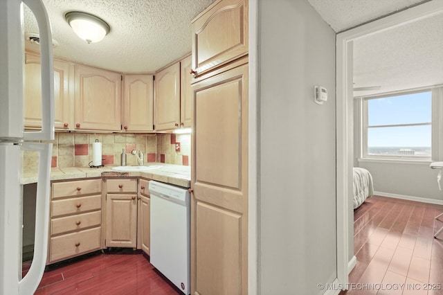 kitchen featuring a sink, tasteful backsplash, a textured ceiling, tile countertops, and white appliances