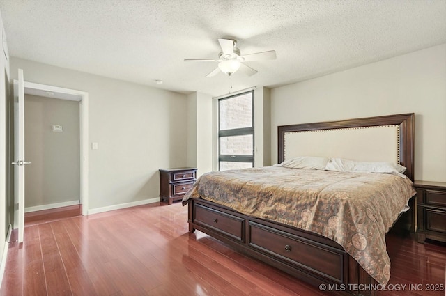 bedroom with ceiling fan, a textured ceiling, baseboards, and dark wood-style flooring