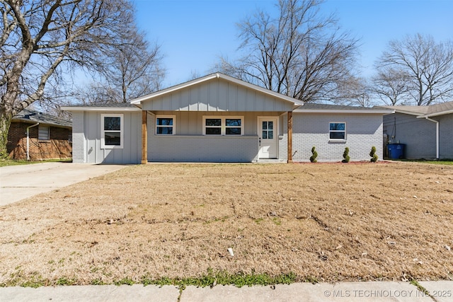 ranch-style home featuring brick siding, board and batten siding, and concrete driveway