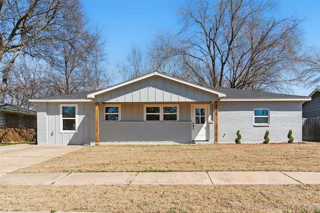 ranch-style home featuring board and batten siding, concrete driveway, fence, and brick siding