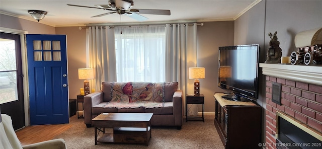 living area with visible vents, carpet floors, a fireplace, crown molding, and ceiling fan