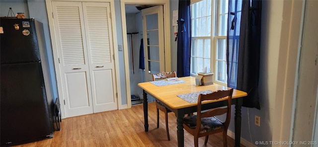 dining area with light wood-style flooring, baseboards, and a healthy amount of sunlight