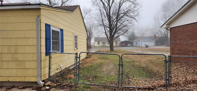 view of yard featuring a gate, fence, and a residential view