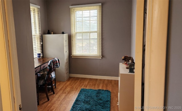 office area with plenty of natural light, baseboards, and wood finished floors