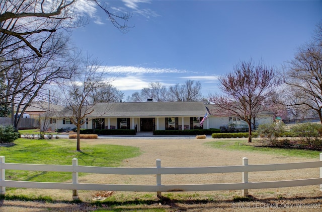 view of front of property featuring a fenced front yard, covered porch, and a front lawn