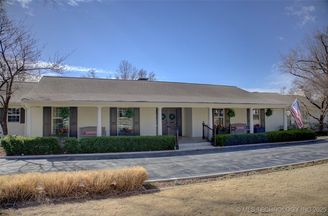 view of front facade featuring brick siding and covered porch