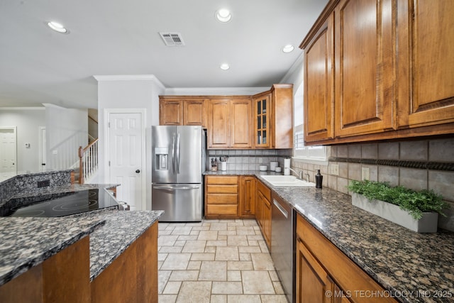 kitchen with visible vents, ornamental molding, backsplash, stainless steel appliances, and brown cabinetry