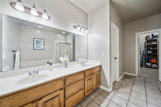 full bath featuring tile patterned floors, double vanity, a stall shower, and a sink