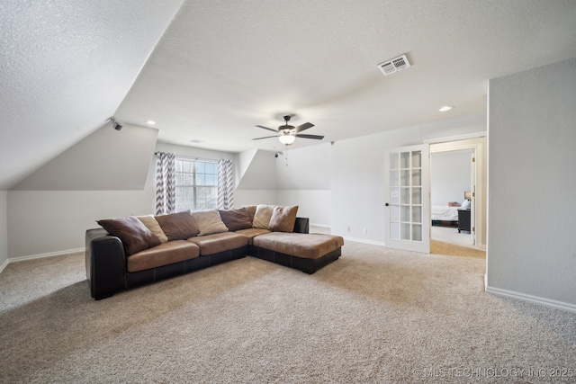 carpeted living room featuring a ceiling fan, baseboards, visible vents, lofted ceiling, and a textured ceiling