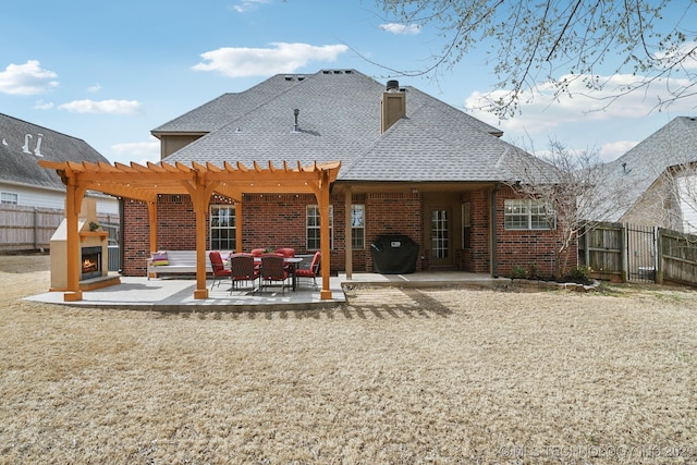 rear view of property featuring a patio, fence, brick siding, and a pergola