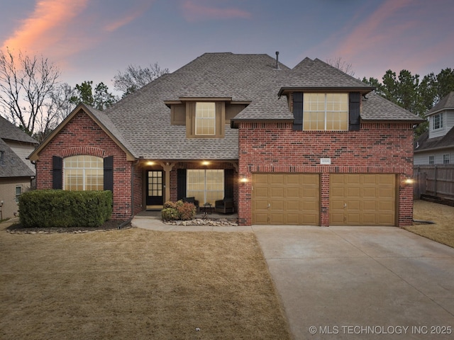 traditional-style house featuring brick siding, concrete driveway, and a shingled roof