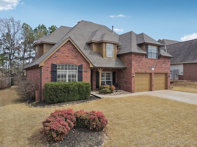 view of front of home featuring brick siding, a front yard, roof with shingles, driveway, and an attached garage