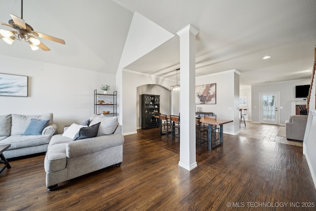 living room featuring baseboards, wood finished floors, a fireplace, and ornamental molding