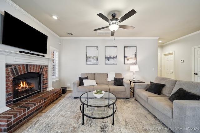 living room with ceiling fan, visible vents, ornamental molding, and a fireplace