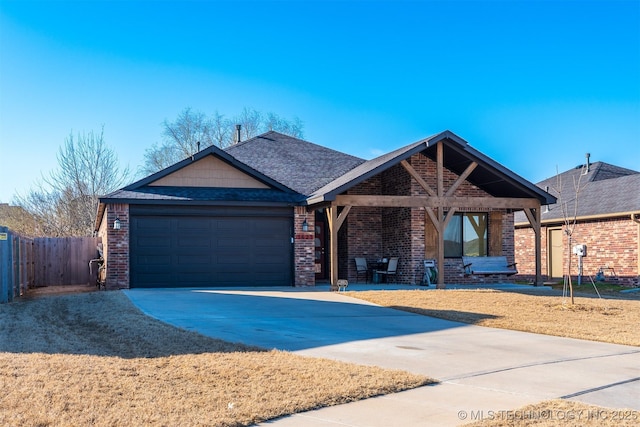 view of front of house featuring fence, roof with shingles, concrete driveway, a garage, and brick siding