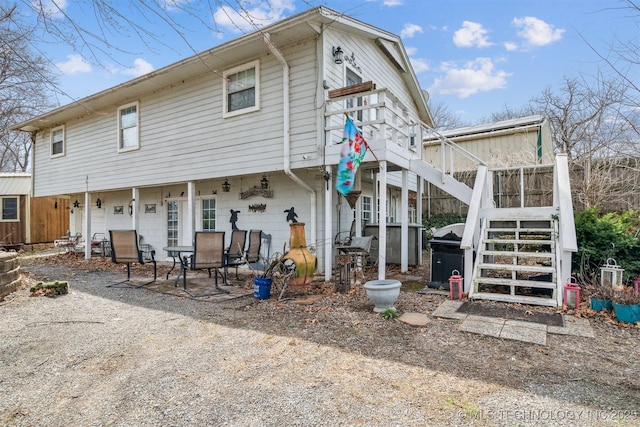 back of property featuring stairs and a patio