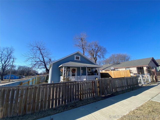 bungalow-style house featuring a fenced front yard and a porch