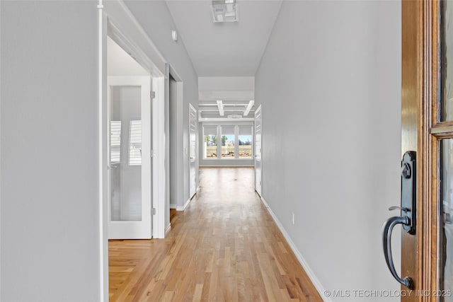 hall with light wood finished floors and baseboards