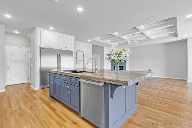 kitchen featuring a center island with sink, recessed lighting, appliances with stainless steel finishes, white cabinets, and a sink