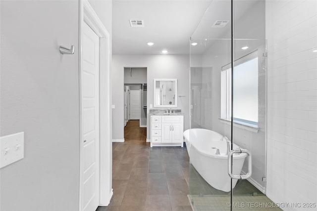 bathroom featuring visible vents, a soaking tub, vanity, and tile patterned flooring