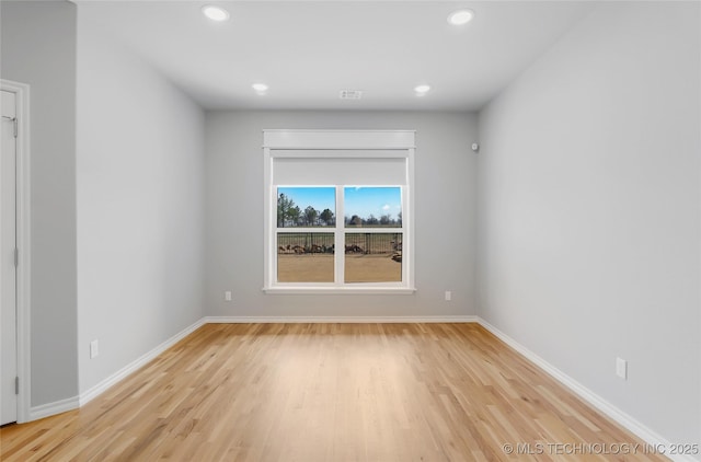 spare room featuring recessed lighting, light wood-type flooring, and baseboards