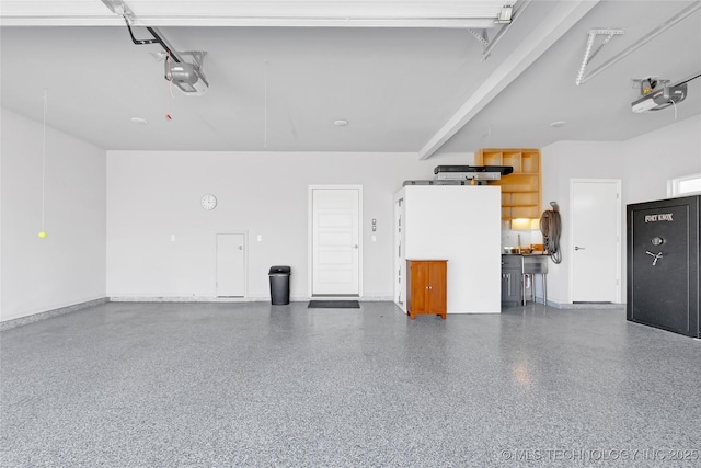 garage featuring a garage door opener and baseboards